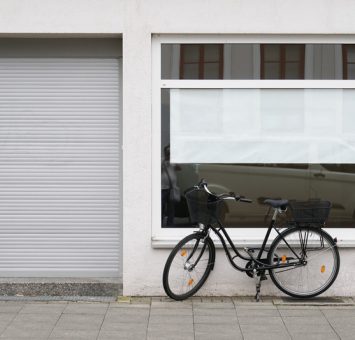 blank vacancy sign or poster with copy space in empty store window with bicycle parked outside closed shop
